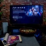Freunde sitzen gemeinsam im Wohnzimmer vor einem Film